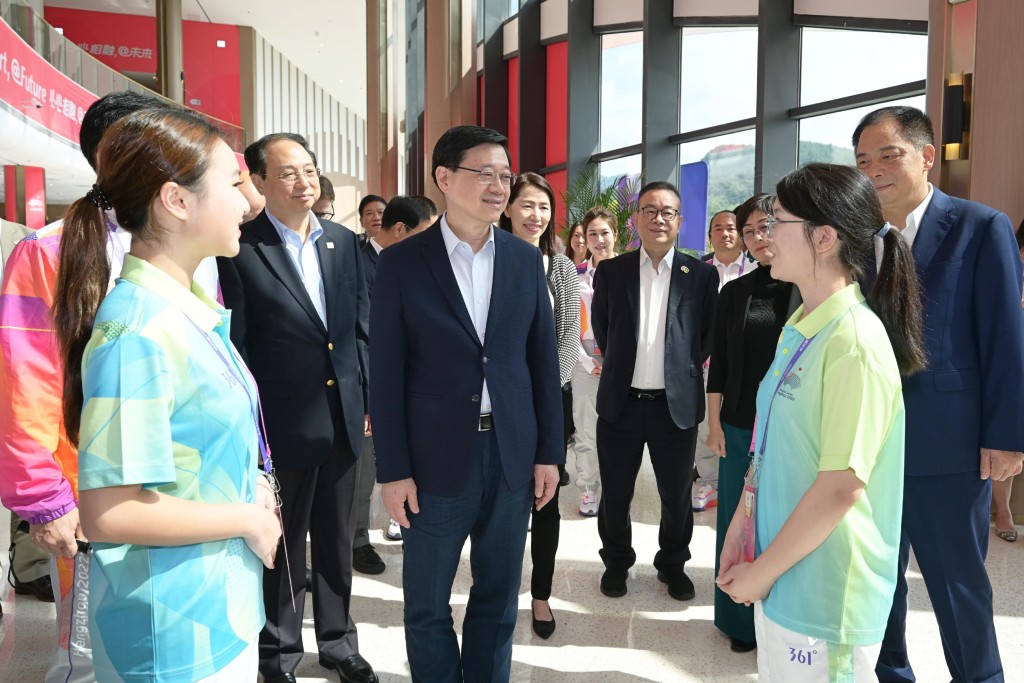 李家超（左三）與杭州第19屆亞洲運動會志願者交流。政府新聞處