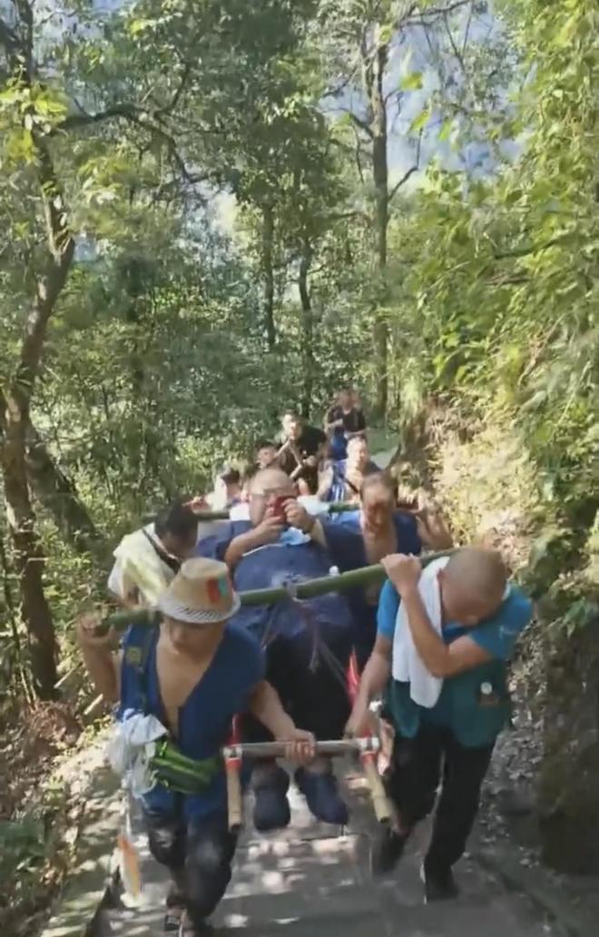 轎夫合力把男子抬上山。極目新聞 轎夫合力把男子抬上山。極目新聞