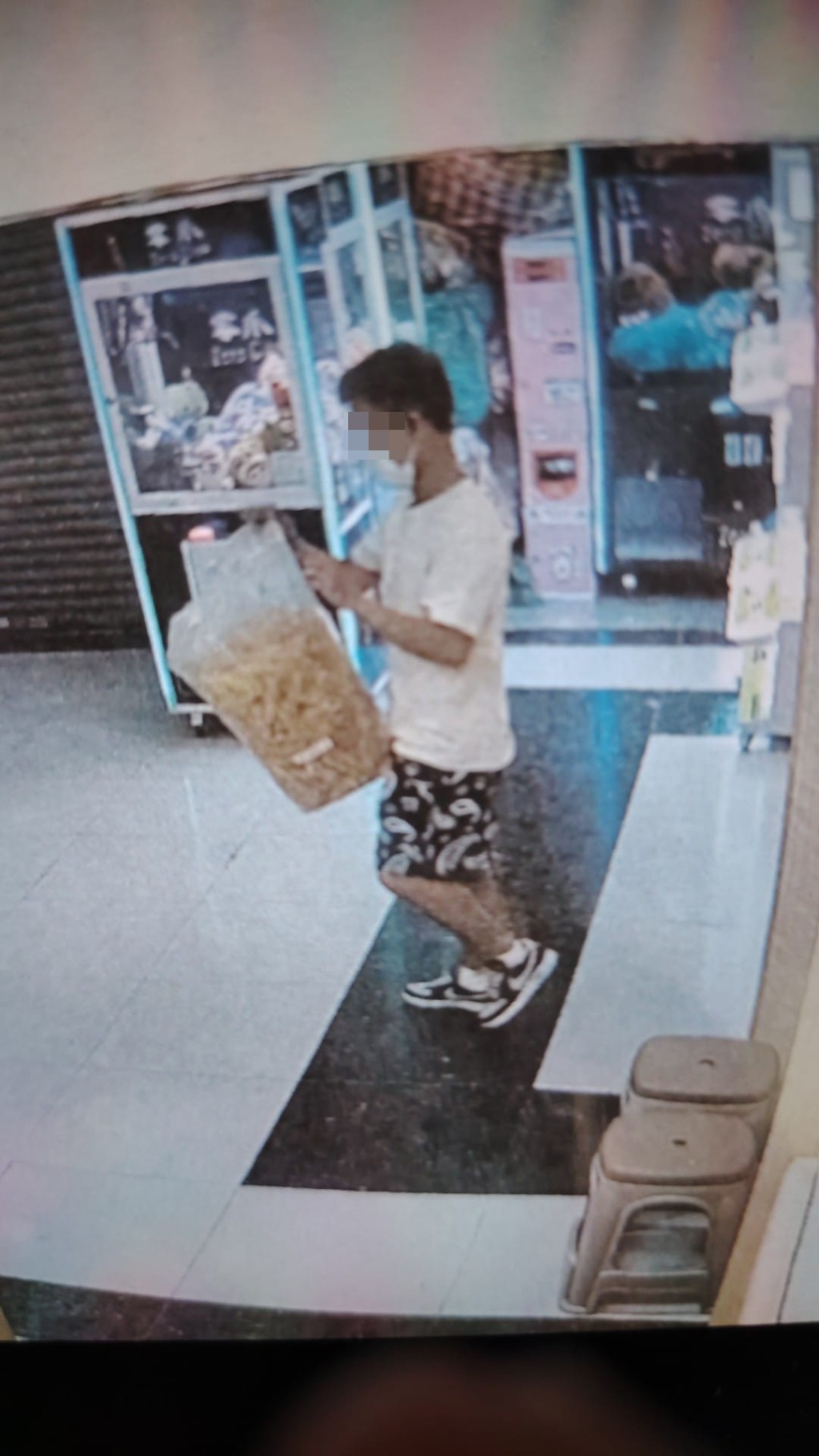 一名白衣男子疑在大埔广场一间药材店内偷走一袋花胶。网上图片