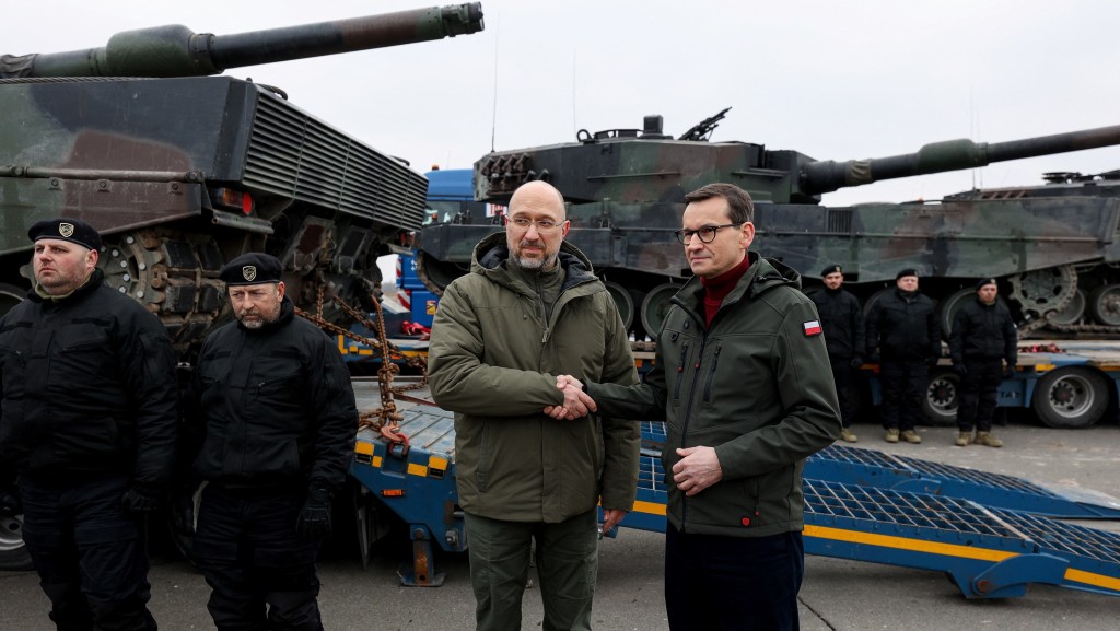 乌克兰总理什米加尔（左）和波兰总理莫拉维茨基在坦克交收仪式上握手。 路透社