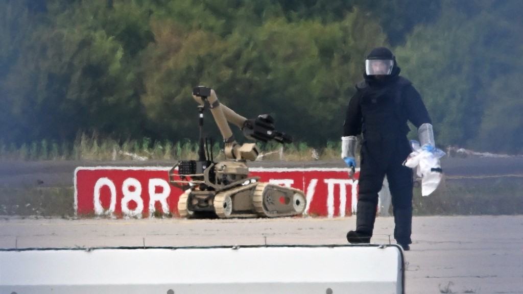 鑑證技術人員出動機械人拆除爆裂物。 美聯社 鑑證技術人員出動機械人拆除爆裂物。 美聯社