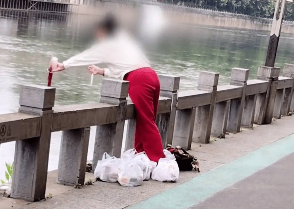 貴州女子在河邊將一杯一杯的奶茶「放生」。