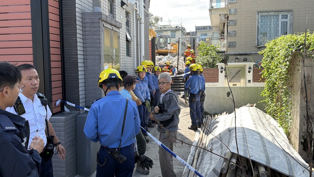 鄰屋屋主到場查看塌牆情況。 鄰屋屋主到場查看塌牆情況。