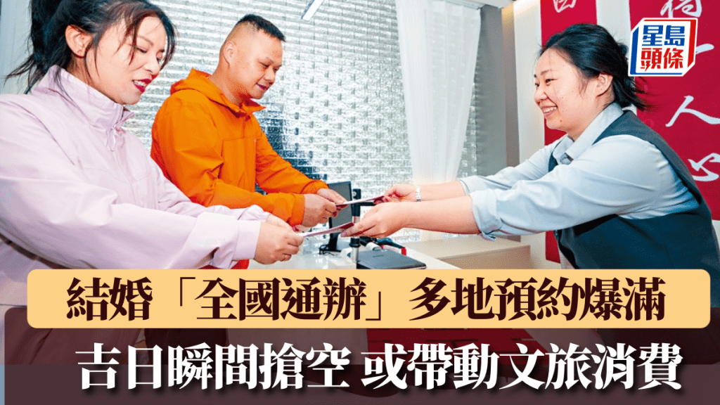 南京市玄武區婚姻登記處工作人員為新人發結婚證。