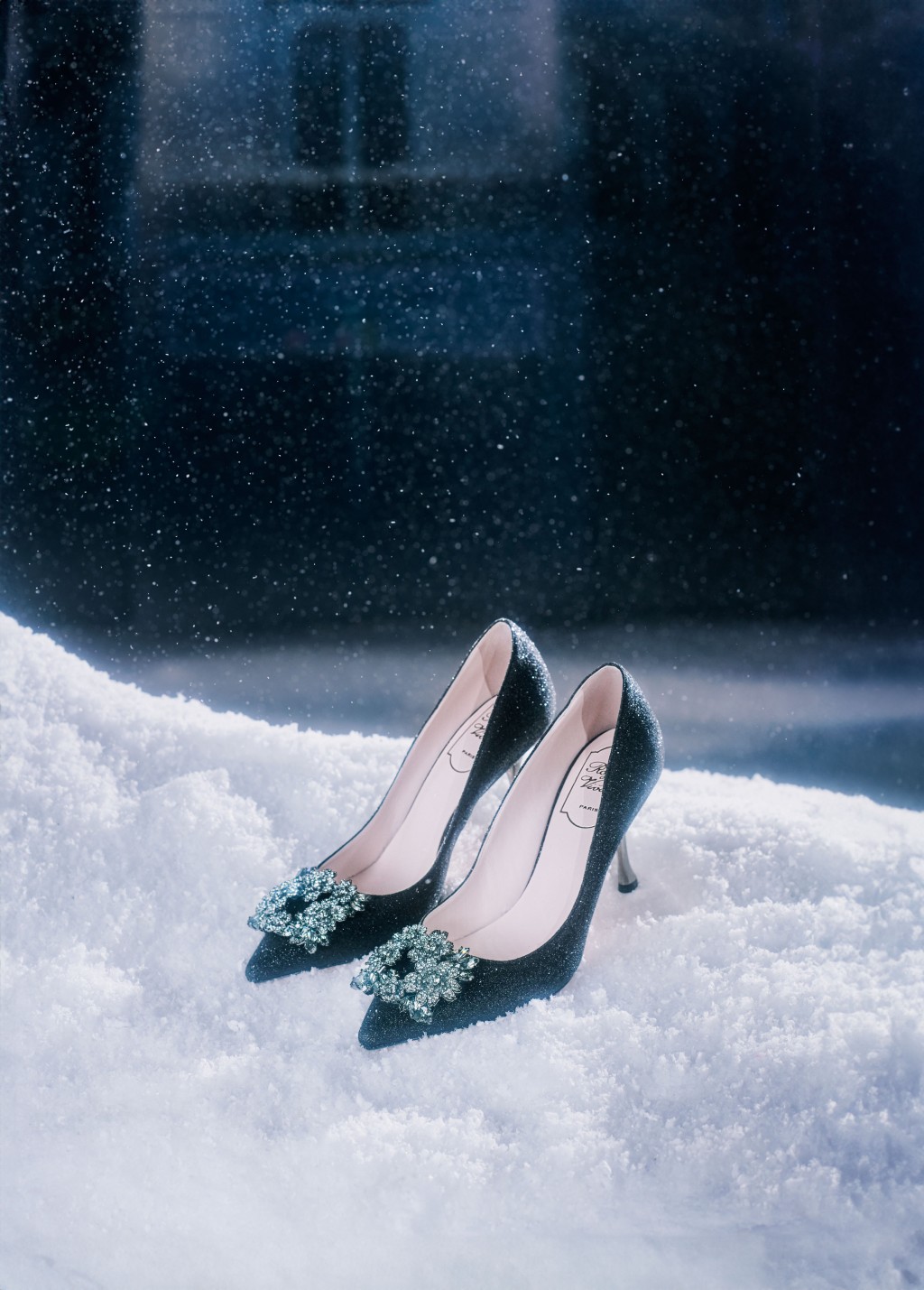 Roger Vivier以「Paris in the Snow」为节日系列主题，这对以闪亮水晶花卉饰扣点缀的高踭鞋，在白雪纷飞的背景下，倍添佳节气息。