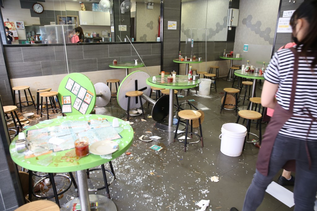 食店內一片凌亂，枱椅翻倒，滿地玻璃碎。劉漢權攝