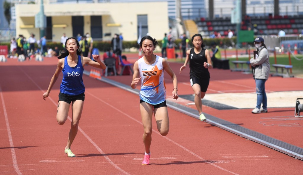 女子甲組100米決賽，李紫桃(白衫)跑贏白凱文 。 本報記者攝