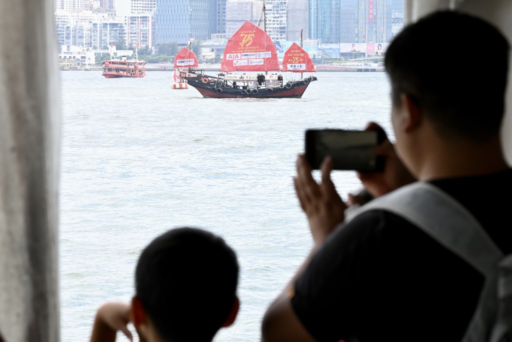 不少旅客举起手机拍摄维港两岸景色。