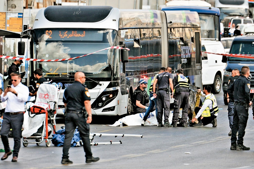 以色列警察在耶路撒冷槍擊現場，為一具屍體蓋上白布。