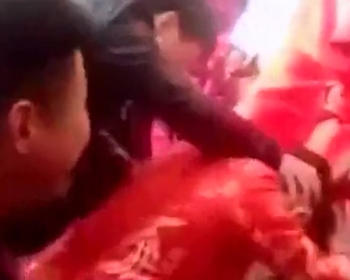 男子掐著新娘颈部，不断逼她跪拜长辈。 网图