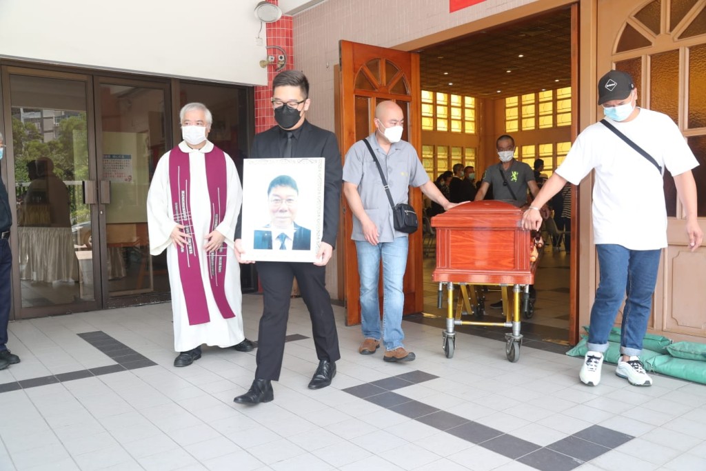 儀式完成後,李唯德神色哀傷捧著父親遺照步出靈堂。