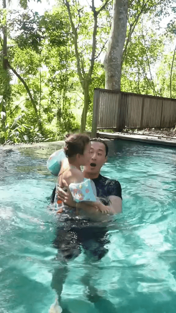 戴上游泳水袖的Luna在爸爸爱的抱抱下，学习闭气潜水和游泳。
