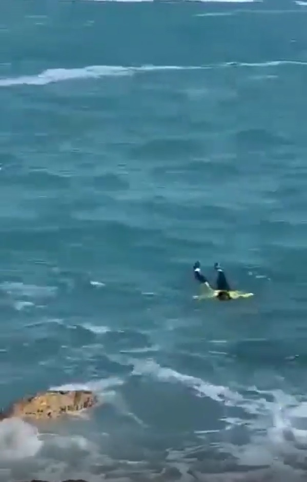 一名身穿萤光褛的女子堕海，在海中载浮载沉。(影片截图)