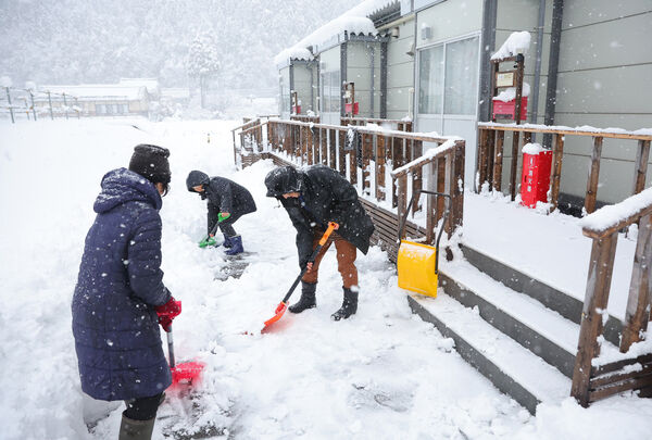 能登地震灾区居民铲雪。美联社