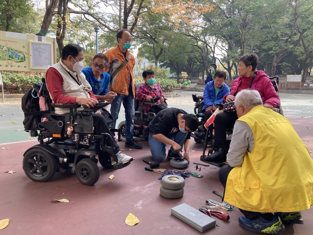 麥Sir(左一)現時每月遊走屯天元地區為殘障同路人免費檢查、清潔及維修電動輪椅。(受訪者提供)