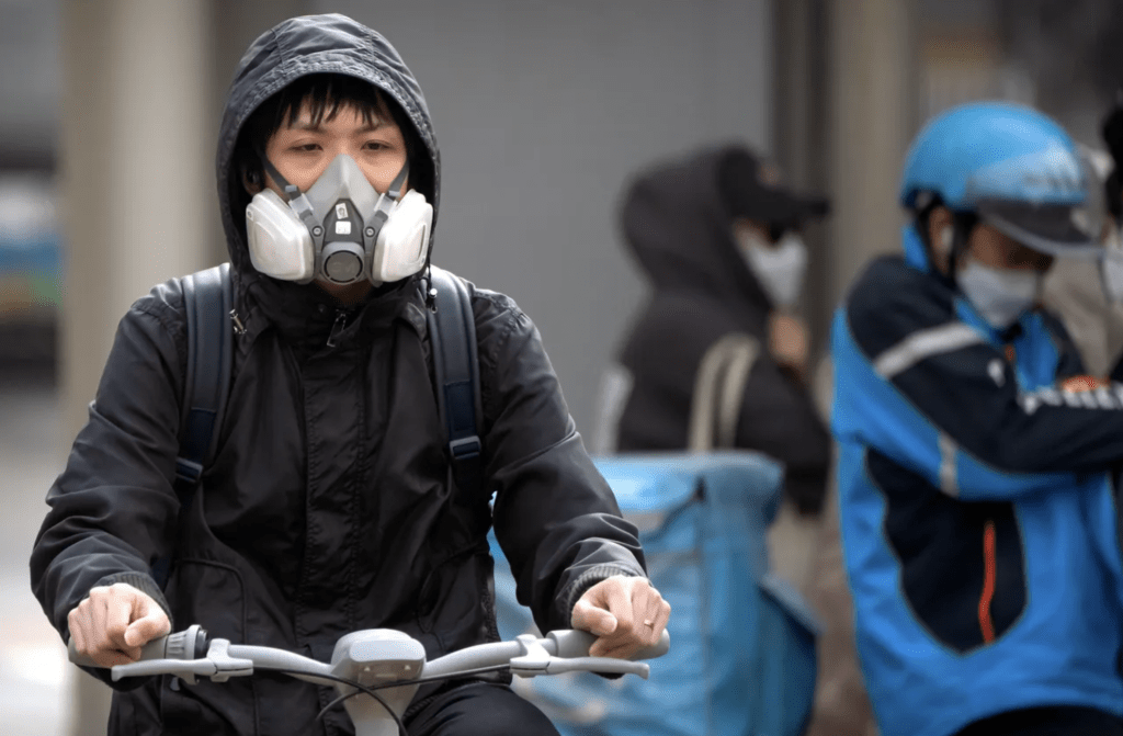 北京市民11日在沙尘暴天气下骑单车出门。美联社