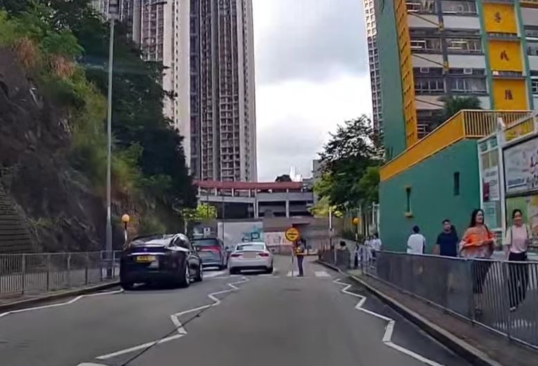白色私家車司機未有理會，驅車在兩線之間直衝過斑馬線。fb車cam L（香港群組）影片截圖