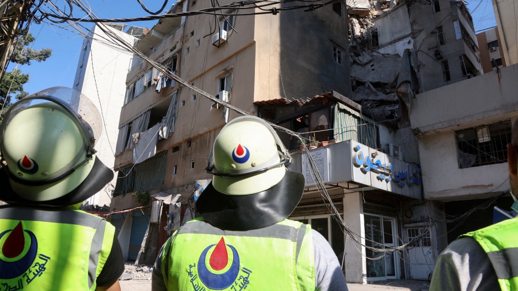 以色列空袭贝鲁特南郊，真主党属下的民防队成员视察受损建筑。 路透社