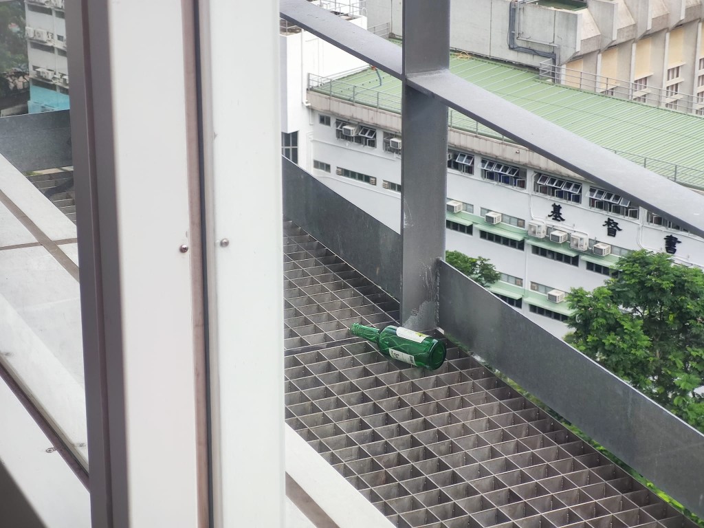 警員在行人天橋電梯塔其中一層發現一個背囊及2個酒樽。梁國峰攝