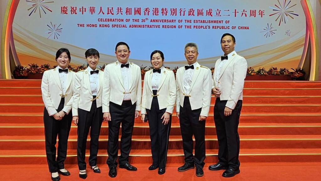 黃君量（左三）與合唱團成員於慶祝中華人民共和國香港特別行政區成立二十六周年酒會演出。