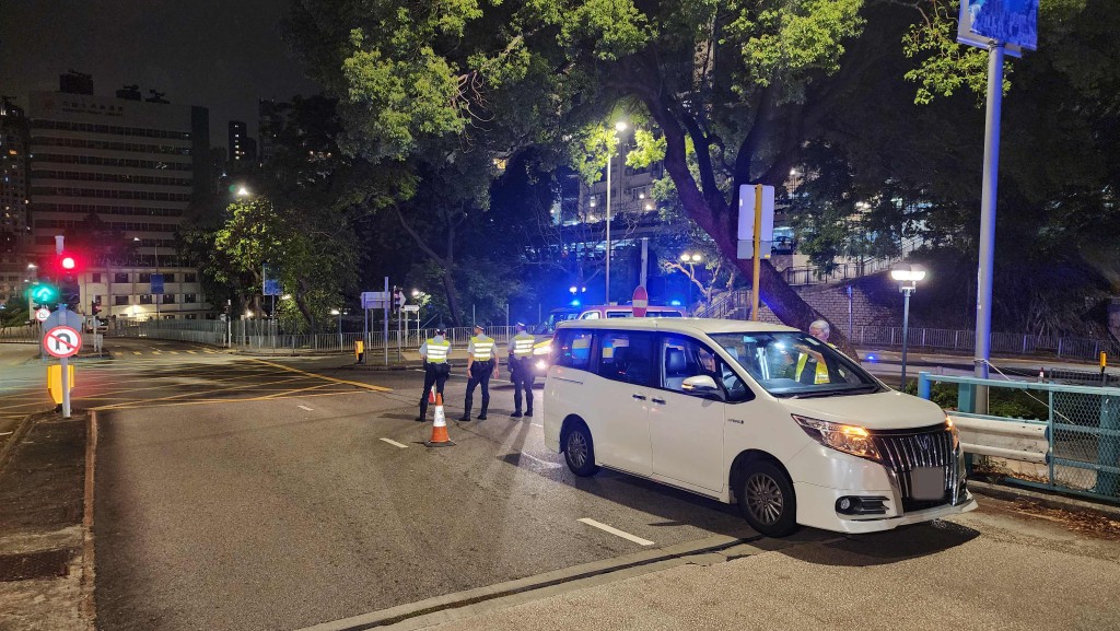 警員在培正道近醫療輔助隊總部將私家車截停。黎志偉攝