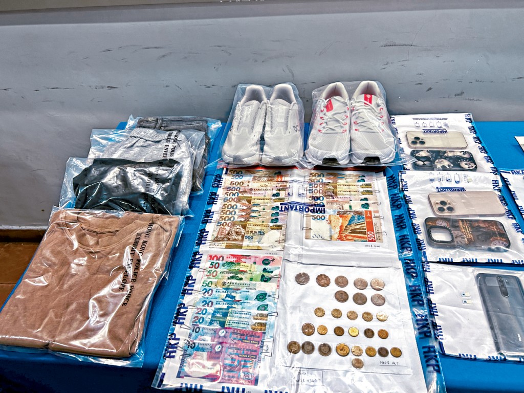 警方展示涉案贓物，當中包括現金和手機等物品。