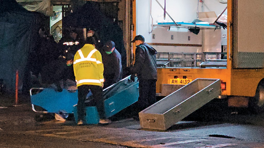 元朗振興新村發生雙屍命案，仵工昨日凌晨將屍體運走。 