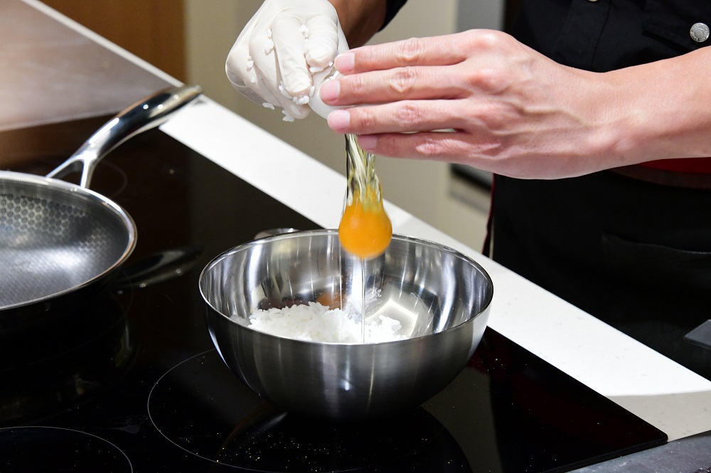 日式炒飯的做法，會先將飯粒與蛋拌勻才炒製。