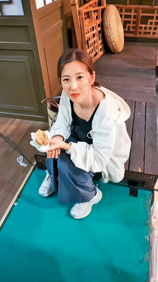 陳自瑤神情憔悴地食麵包，與王浩信在酒店悠閒食早餐大相逕庭。