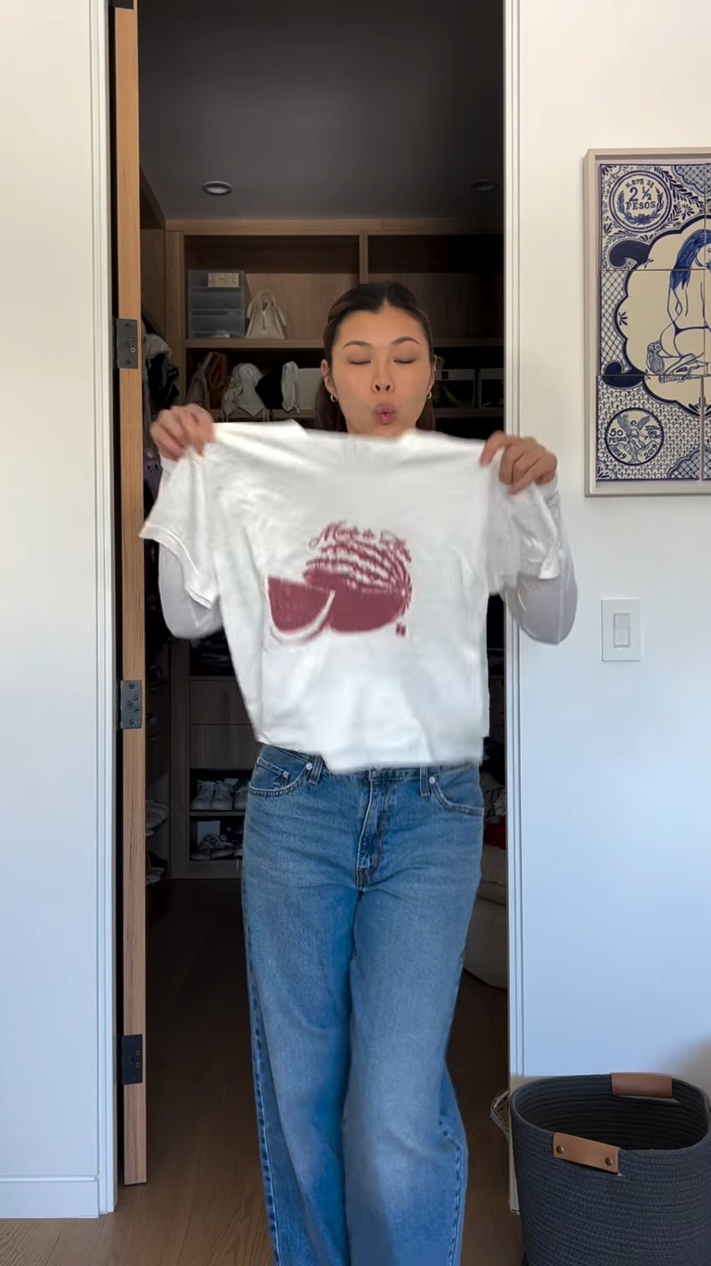 其后王曼喜便穿上一件白色长袖底衫及印有红色水果图案的T恤，再穿上黑色长皮褛及酒红色长靴，整体造型既简约又不失质感。