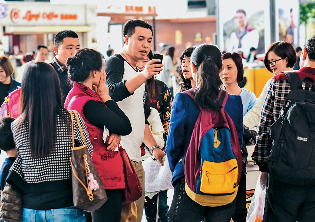 一位赴韓國旅遊團的導遊在廣州白雲國際機場向團員介紹有關事項。