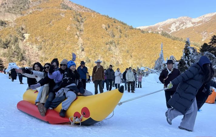 康定木格措，遊客坐雪地衝鋒舟遊玩。