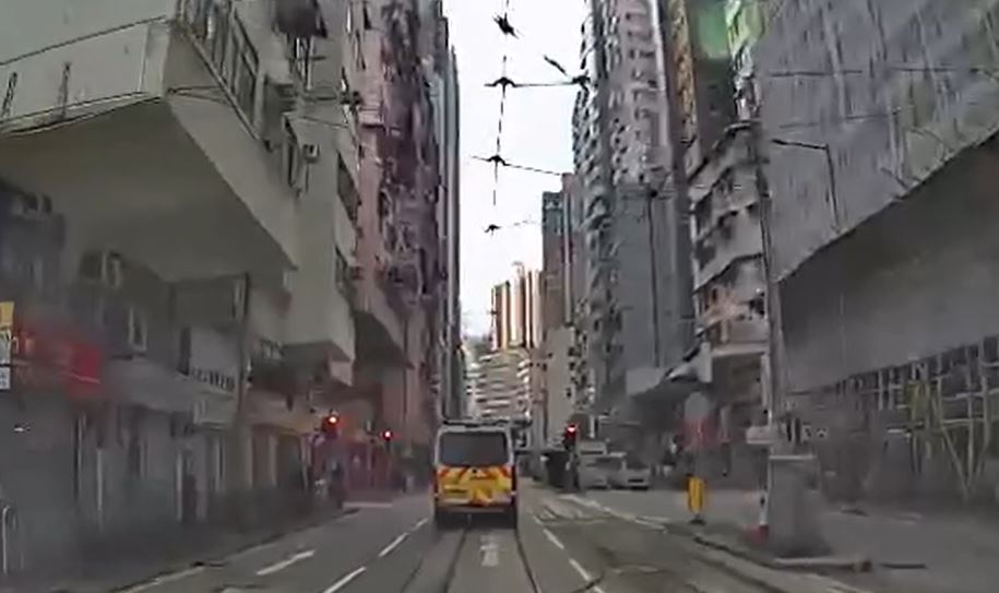警車沿筲箕灣道駛至新成街交界燈位，交通燈顯示為紅燈。fb香港突發事故報料區影片截圖