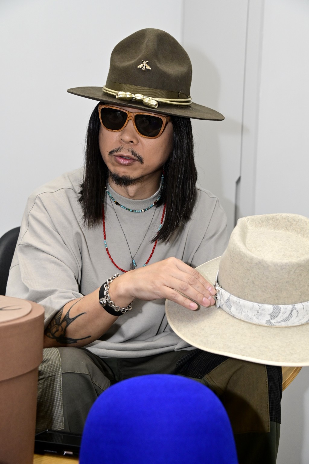 王雙駿當時在演唱會擔任服裝的朋友。專登為這個騷設計了這章：「有啲扣咗喺件衫，我咪扣咗喺頂帽。」