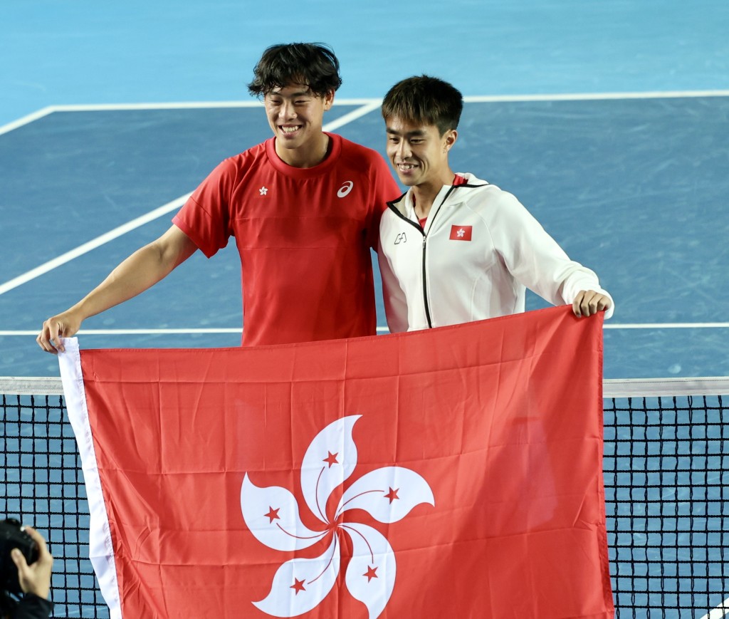 今日两位男单功臣黄泽林(左)及王康杰(右)赛后带著特区旗在场中间合照. 