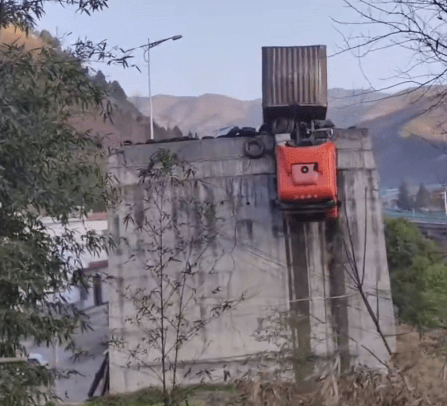 剎車失靈貨櫃車衝出公路，拖頭90°懸掛半空，司機受困，如身處懸崖。 陝西消防