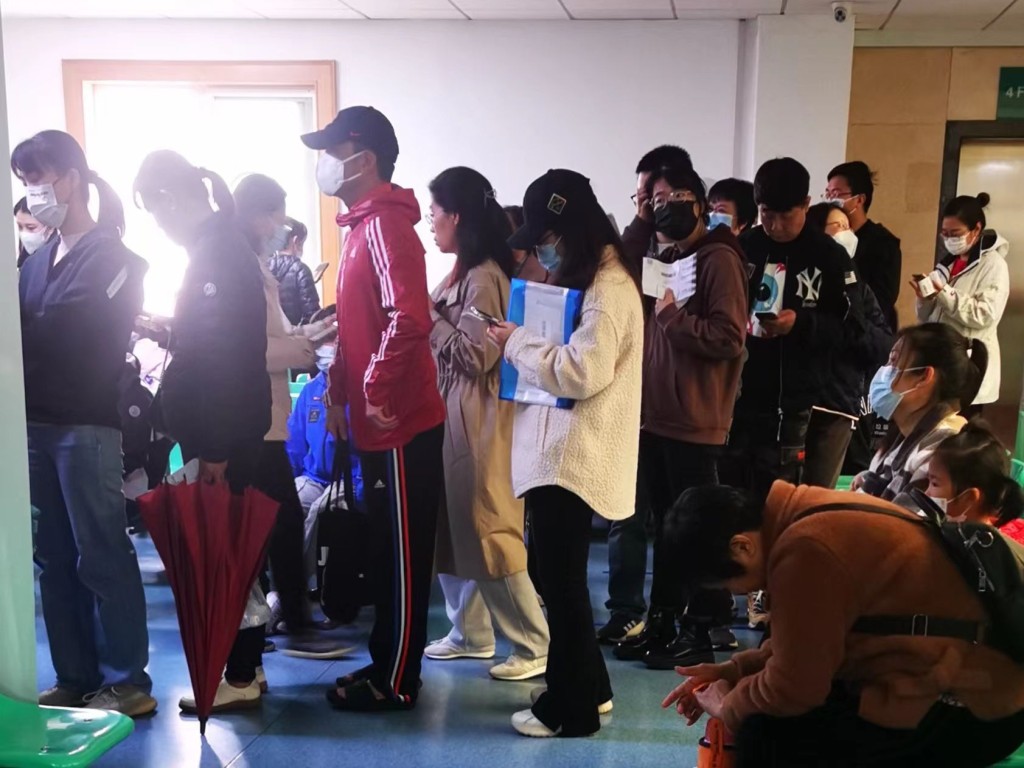 北京海淀区一家社区医院儿科人满为患，排队的人龙挤到电梯口。 杨浚源摄