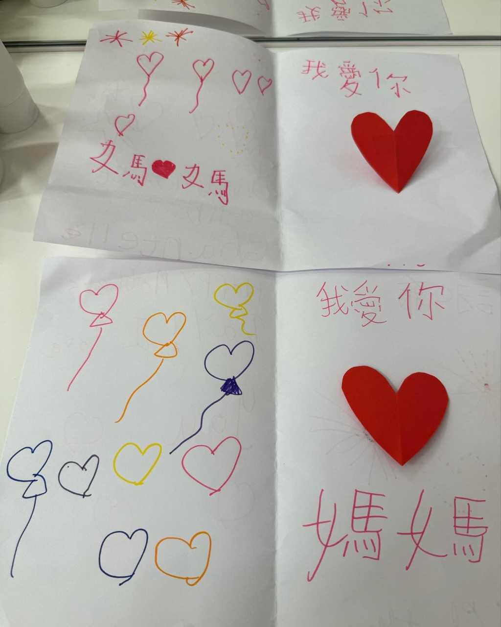 心意卡的内页用上红、橙、黄及蓝色画上烟花及气球，并在右边贴上心心，并再写上「我爱你 妈妈」字体简洁整齐。