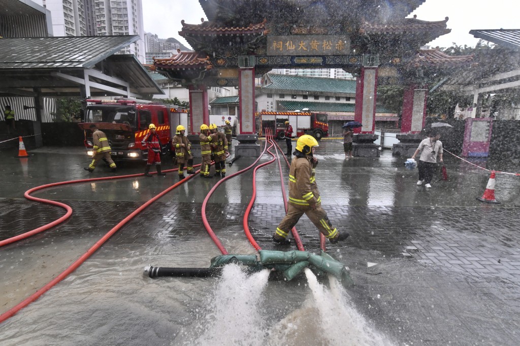 大批消防員到黃大仙中心外協助清理積水。陳極彰攝