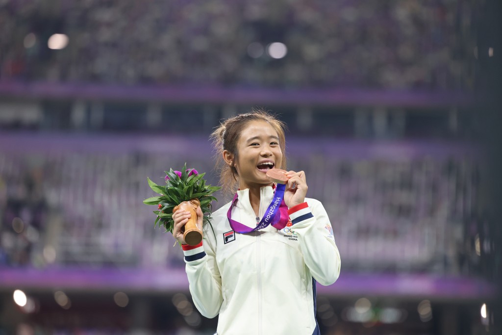 俞雅欣跳遠驚喜得銅牌，輕咬獎牌慶祝。 徐嘉華杭州傳真