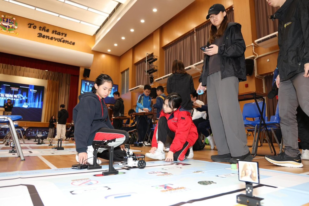 小學生聚精會神操控智能車,透過模擬場景實踐道路安全知識。 小學生聚精會神操控智能車,透過模擬場景實踐道路安全知識。