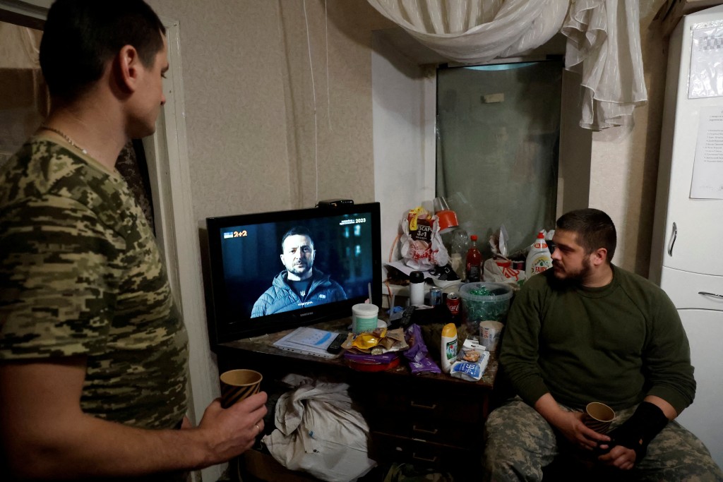 在乌克兰顿涅茨克地区，在俄罗斯对乌克兰发动攻击期间，乌克兰士兵观看乌克兰总统泽连斯基新年演说。路透