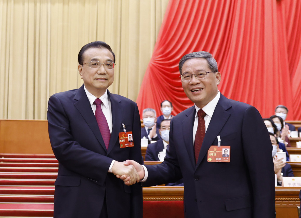 63歲的李強被確認為新一任總理，與上任總理李克強握手。