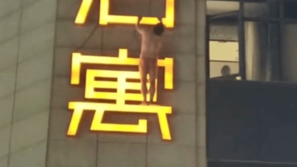 男子雙手抓住廣告牌。微博