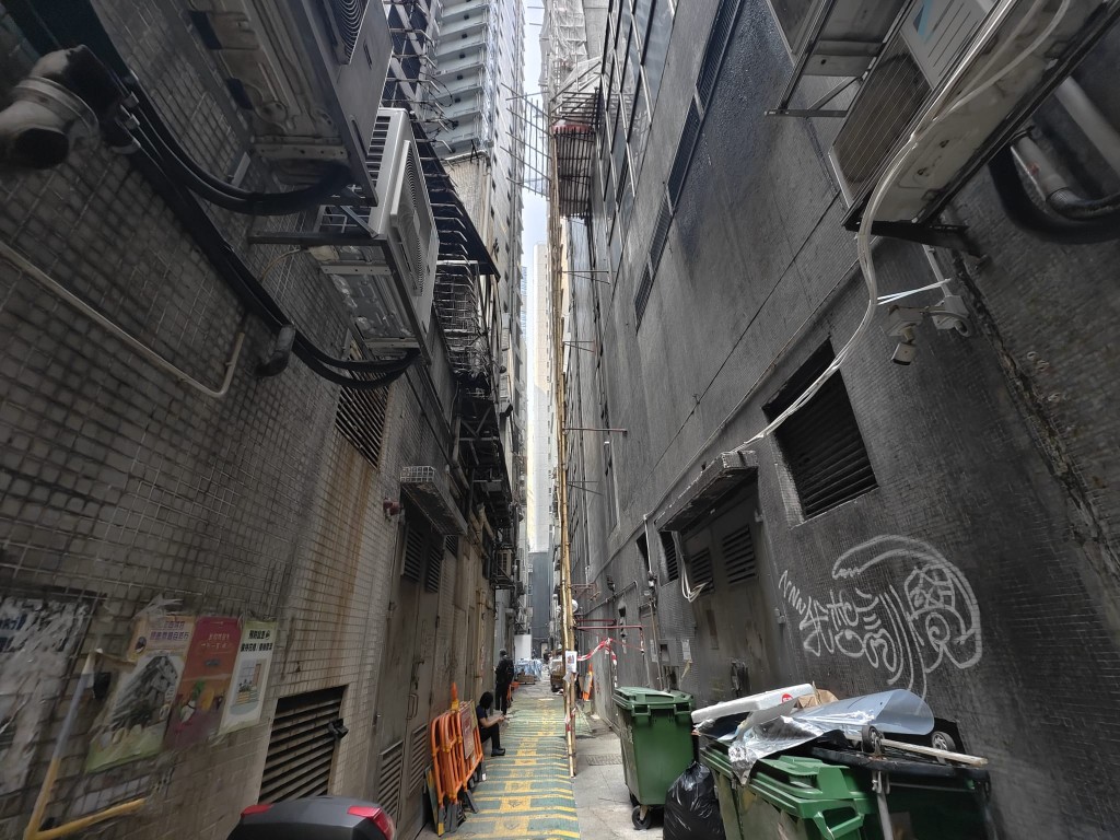 女子在後巷疑遭墮下鐵通擊頭重創昏迷。 女子在後巷疑遭墮下鐵通擊頭重創昏迷。