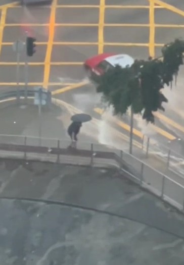 有相信是前往東區醫院返工的打工仔，為避開水浸，不惜冒生命危險爬上路旁的防撞護欄。網上影片截圖