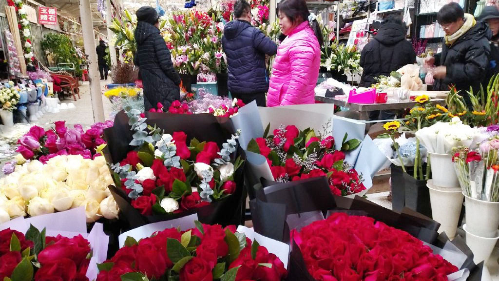 今日是情人节，不少男士们到花店购花。微博图