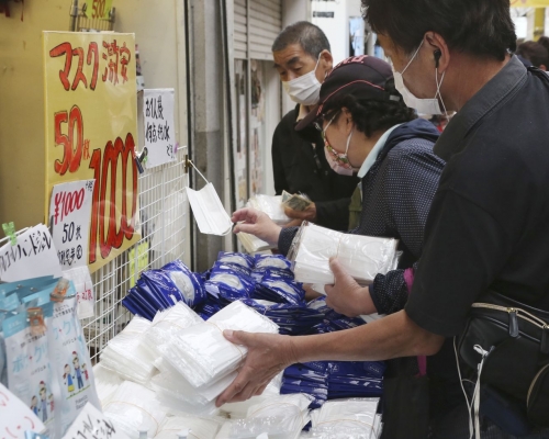 在新冠疫情下,日本民眾選購口罩等物品。AP