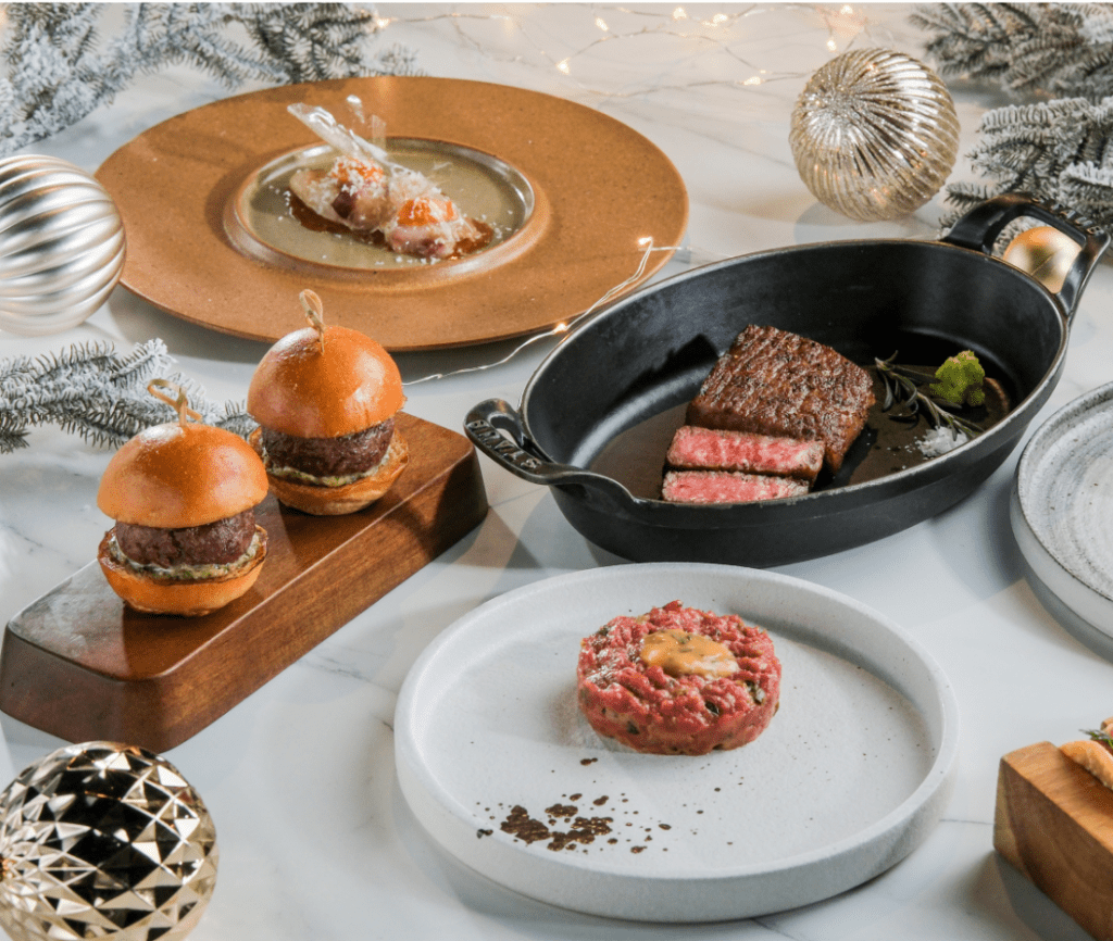 炭火烤盤上呈現完美的肉扒，旁邊伴有精緻的牛柳他他，展現了肉質的鮮嫩與多樣的烹調手法。