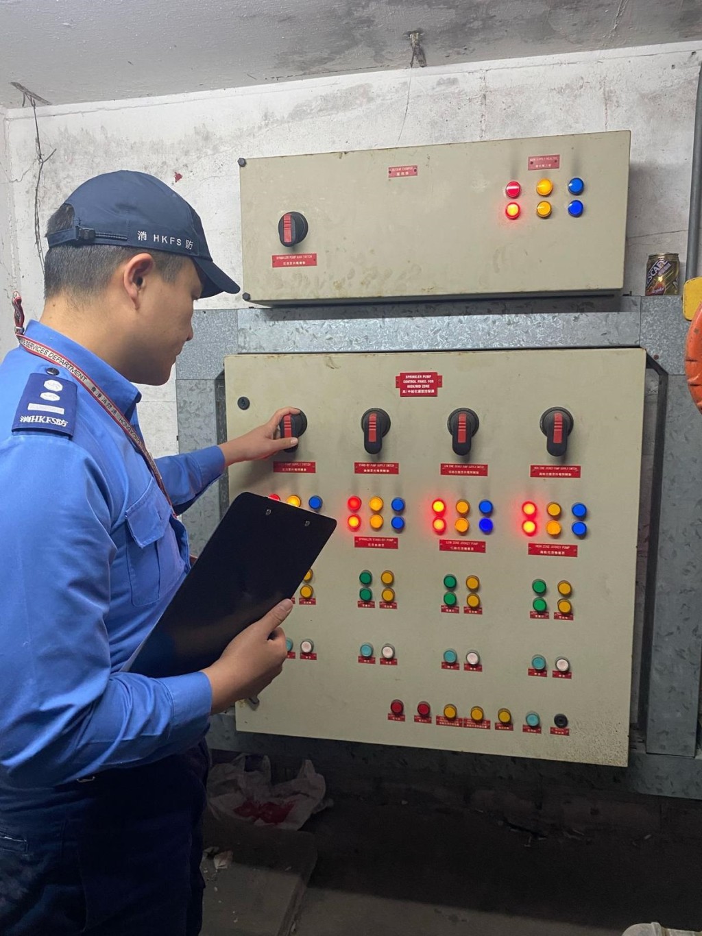 消防人員檢查大廈消防栓喉轆系統的電源狀態。